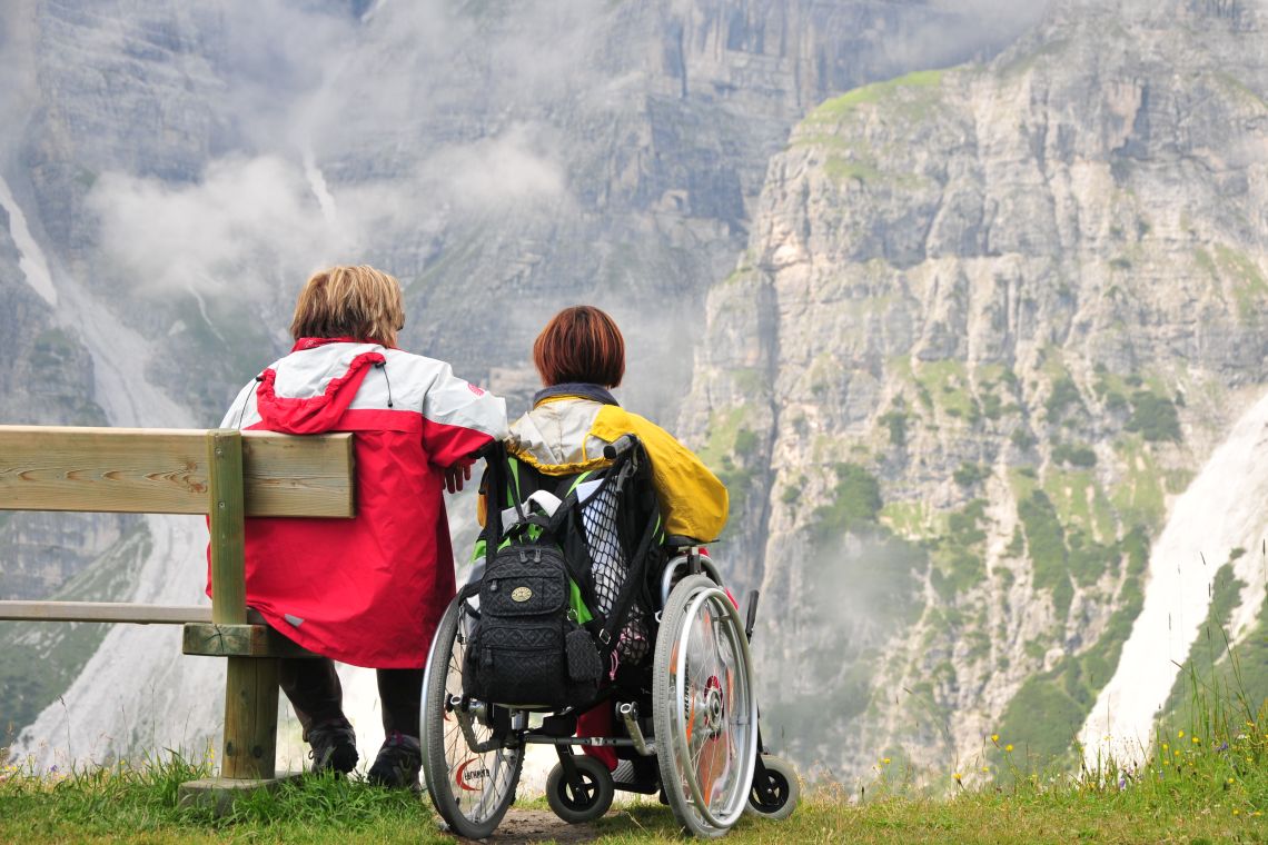 Zwei Frauen, eine davon im Rollstuhl, bei ihrem Urlaub in den Bergen.