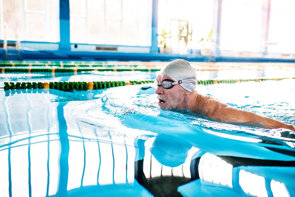 Seniorenschwimmen: Ein älterer Mann zieht in einem Hallenbad seine Bahnen