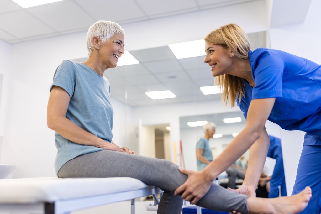 Osteoporose im Alter: Eine Physiotherapeutin behandelt eine ältere Dame mit Osteoporose